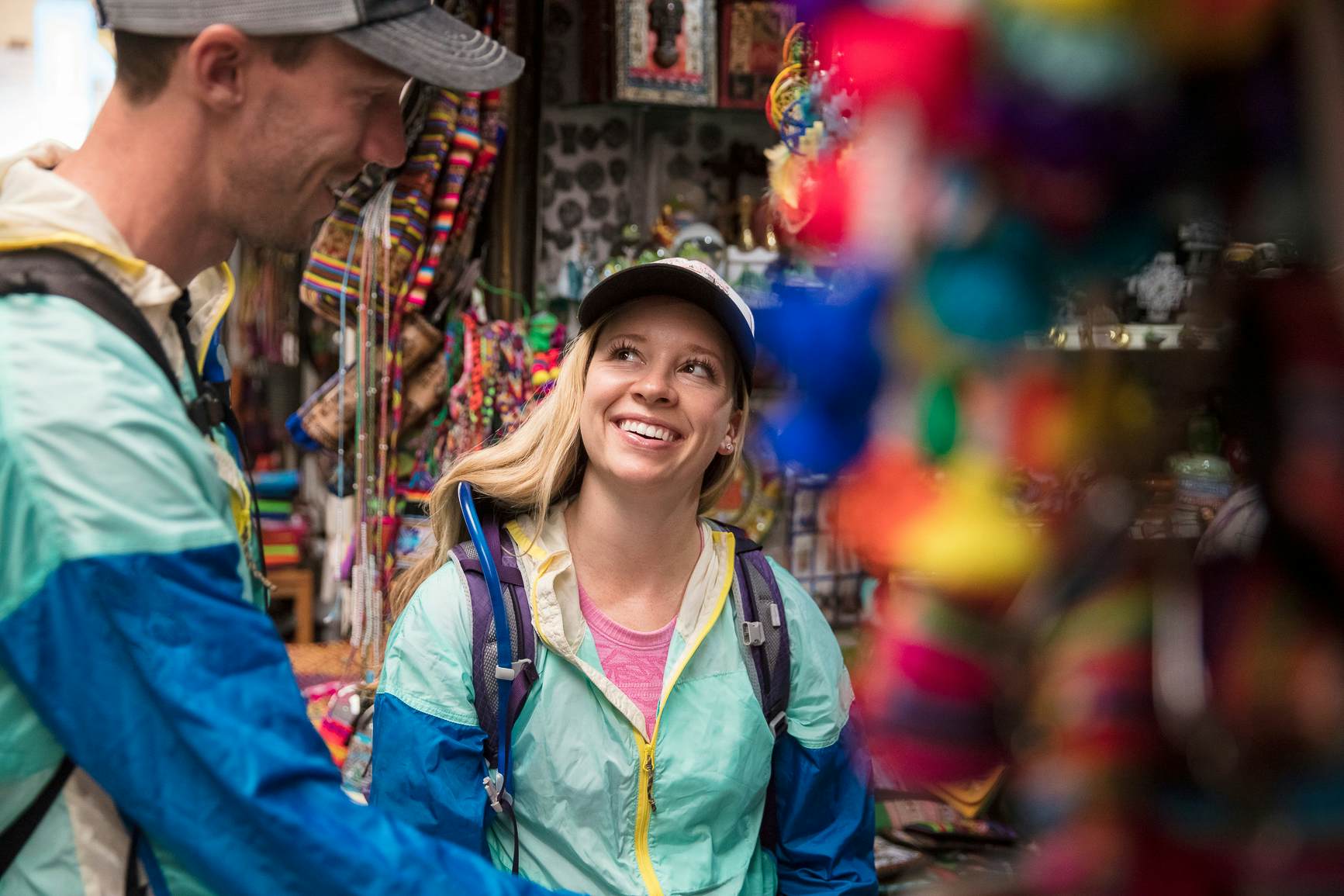Young caucasian man and woman shopping for souvenirs in a local market in Cusco, Peru.